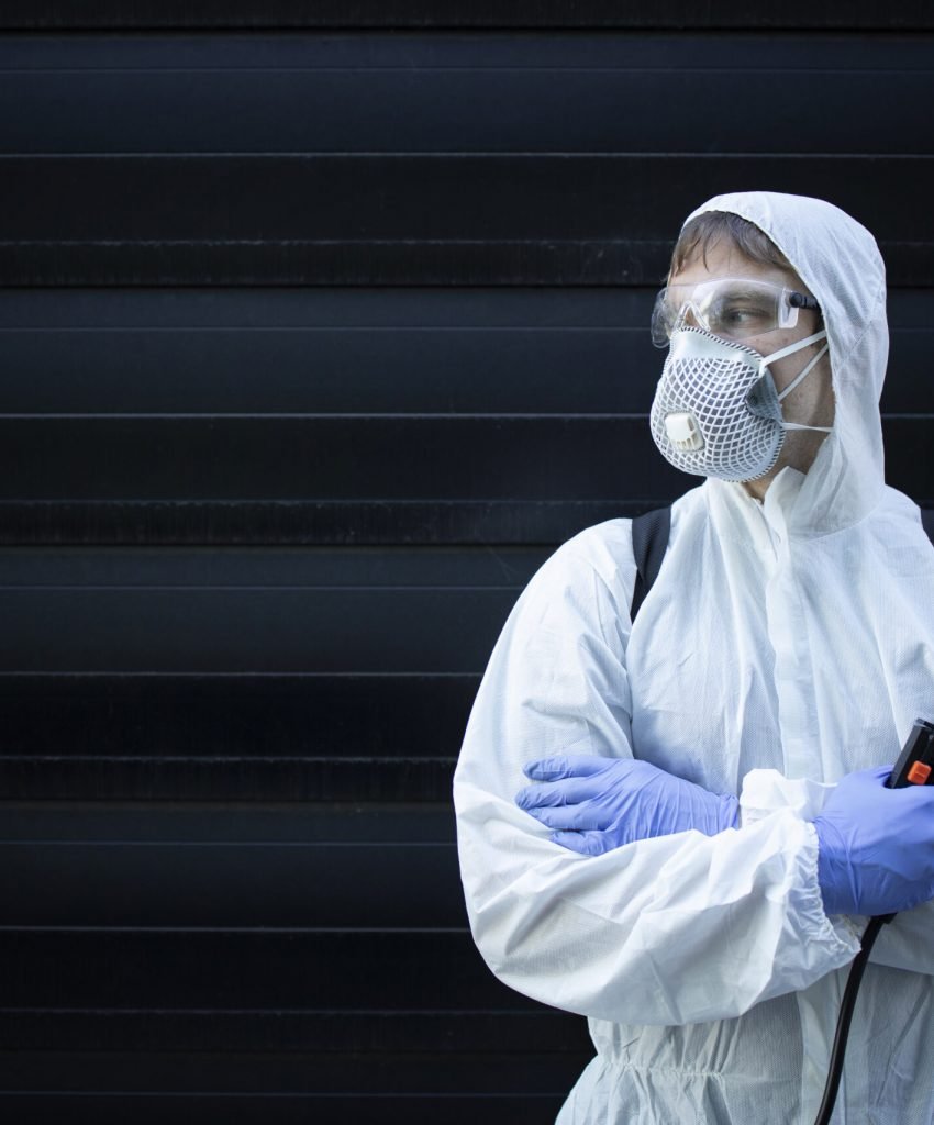 Portrait of professional exterminator holding sprayer with chemicals for pest control.